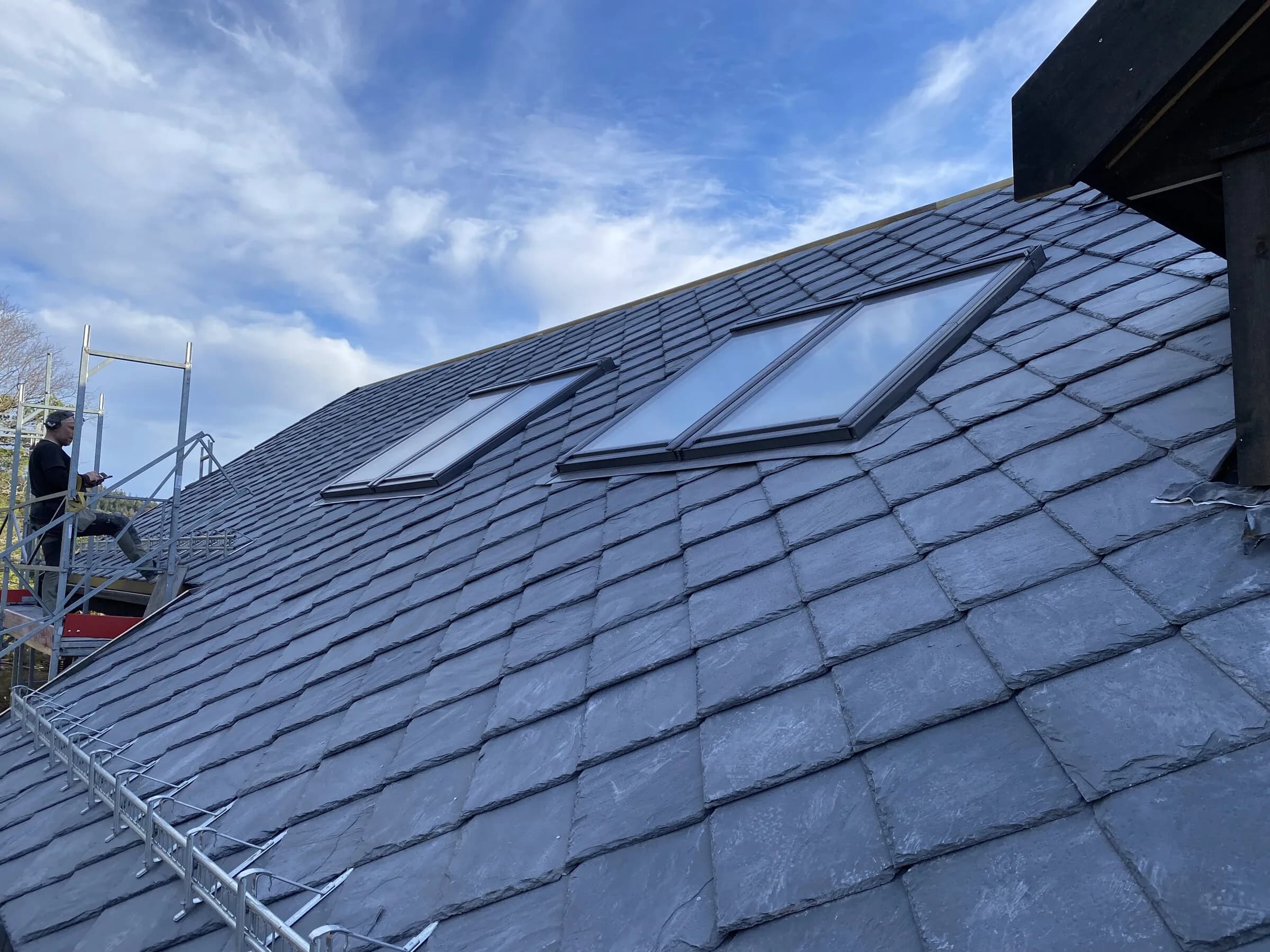 Detalj av skifertak med takvindu og fjellutsikt