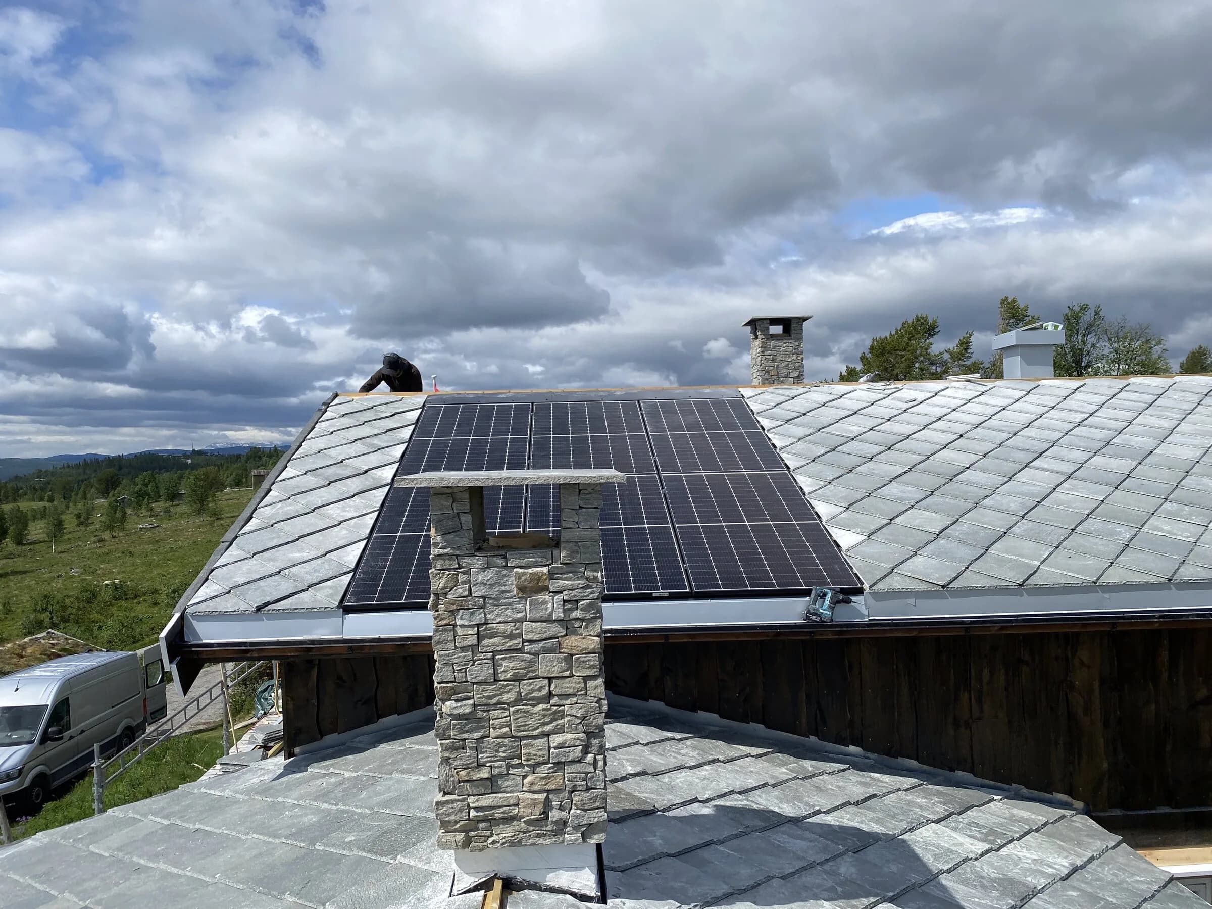 Skifertak med solcellepanel og steinpipe