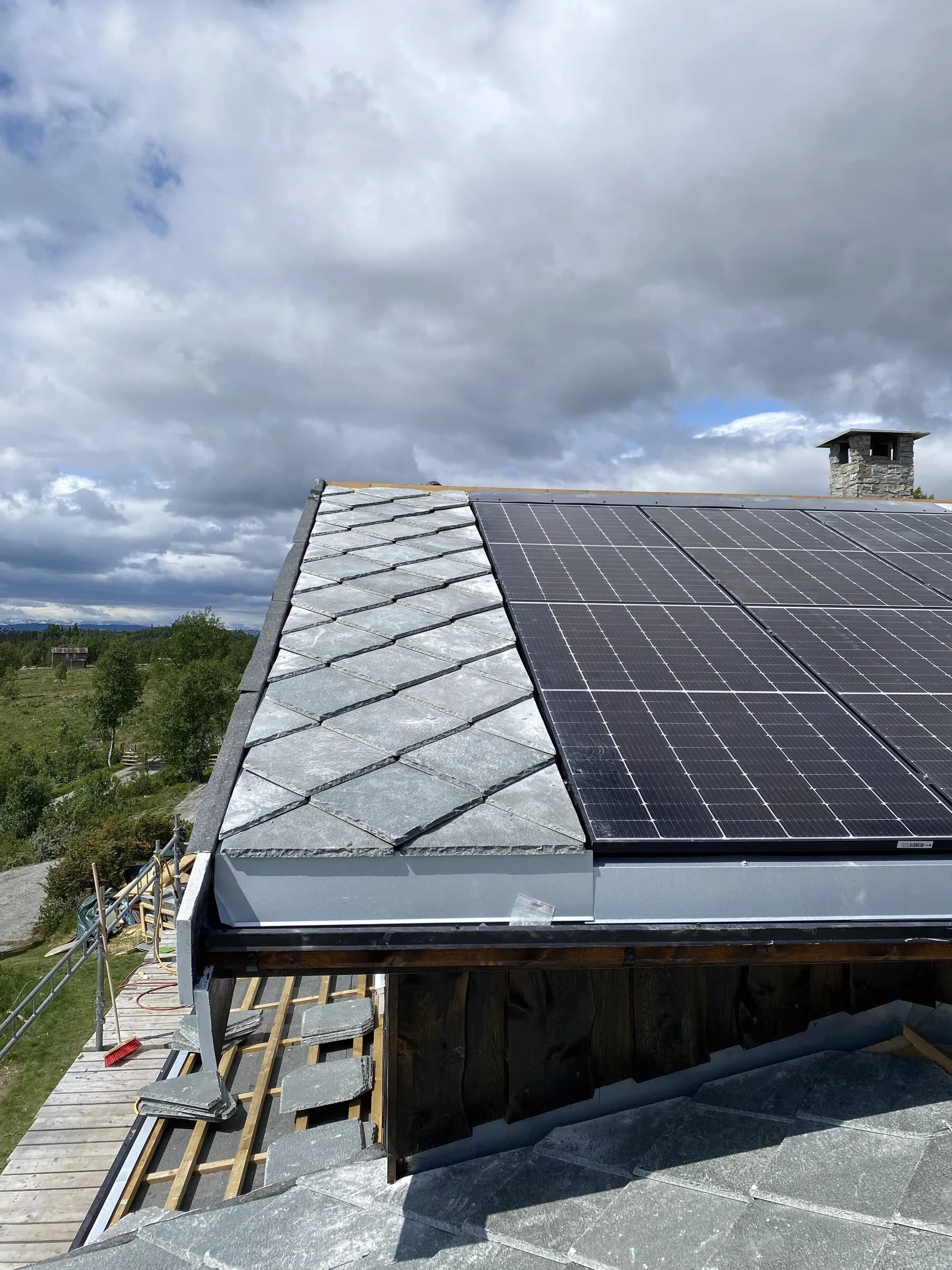 Skifertak med solcellepanel og fjellutsikt