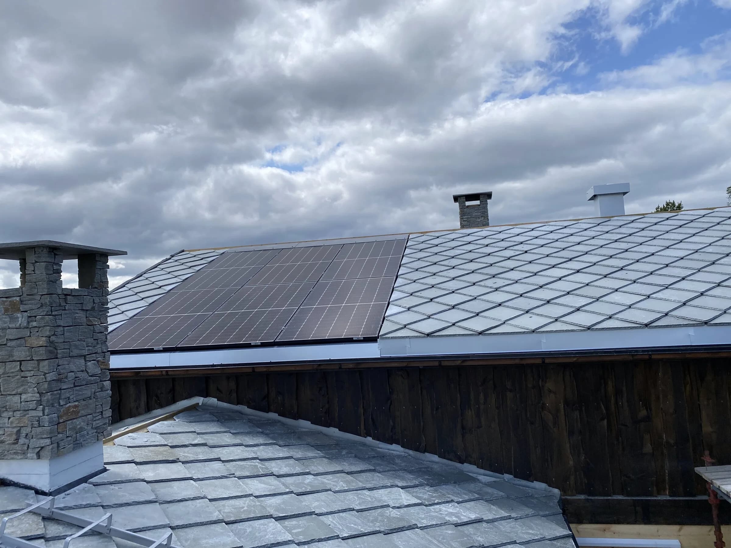 Skifertak med pipe under skyet himmel